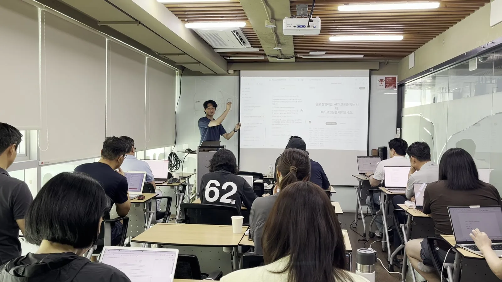강남 오프라인 교실에서 수강생들이 노트북으로 실습하고 강사가 앞에서 설명하는 모습